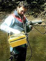 Image of Professor Ken Rastall using YSI 3800 Water Quality Logger to measure several chemical parameters of stream water quality at once.