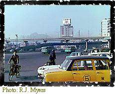 Image showing a fairly typical street scene in downtown Seoul- roads, cars, and people riding bikes.