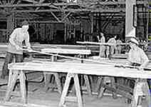 Image of men working in a lumber yard.  This image links to a more detailed image.