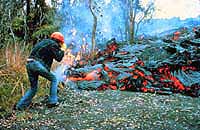 Image of a volcanologist taking a picture of a lava flow.  This image links to a more detailed image.