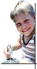 Image of a boy standing at a water fountain.